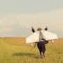 Boy running in the field with airplane wings